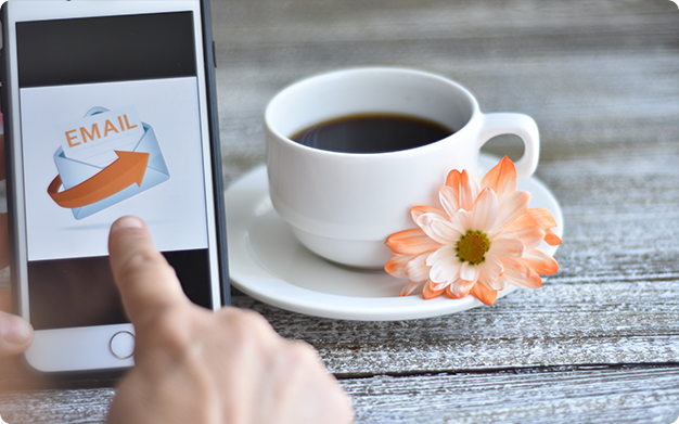 Smartphone with the words ''Email'' written on it and a coffee next to it