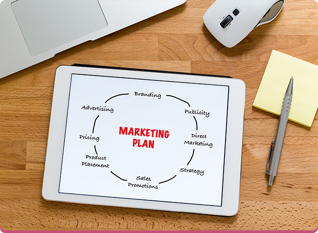 Marketing plan written on a tablet screen on wooden background