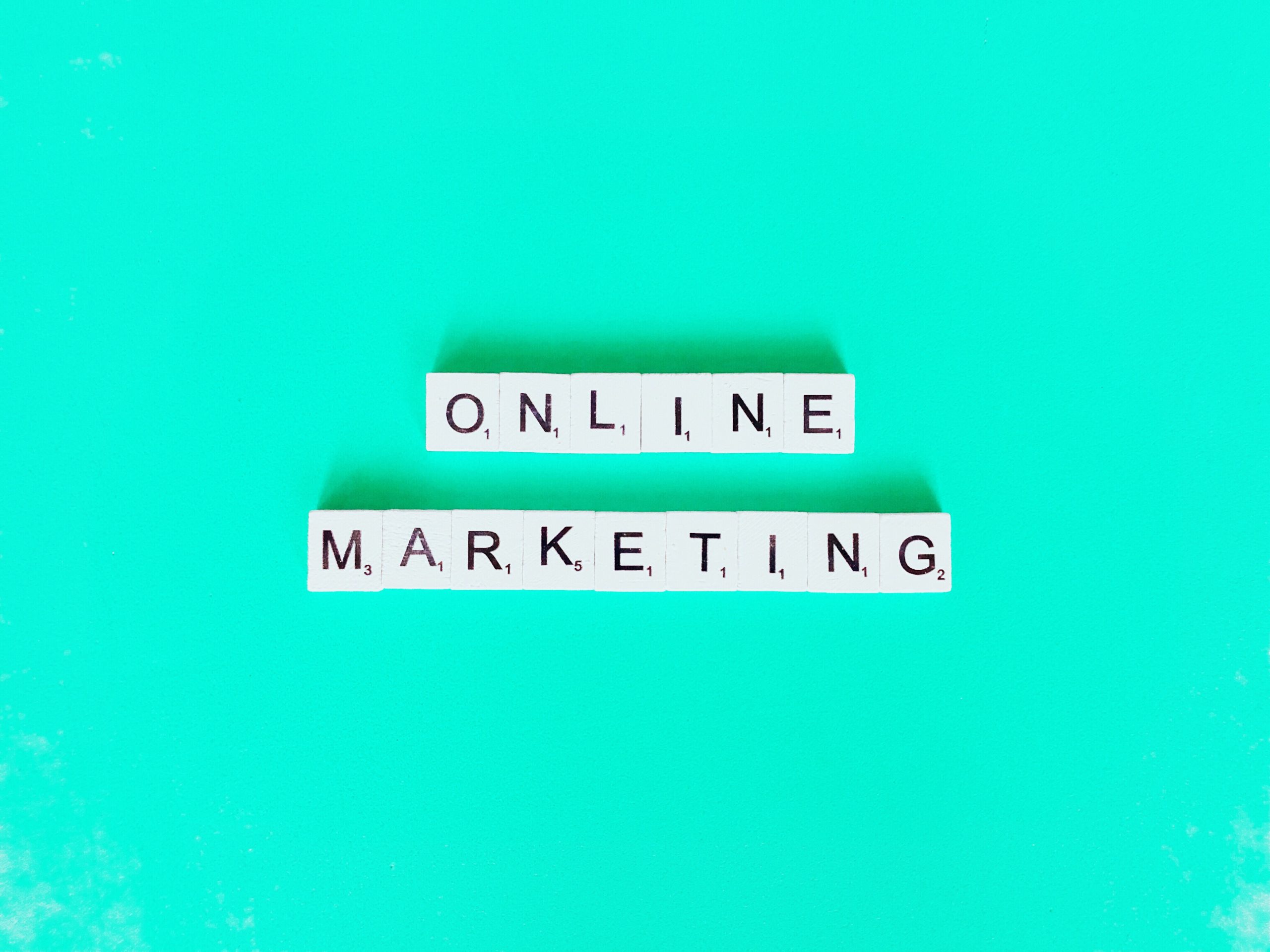 The words ''Online Marketing'' written on white wooden pieces on a blue background